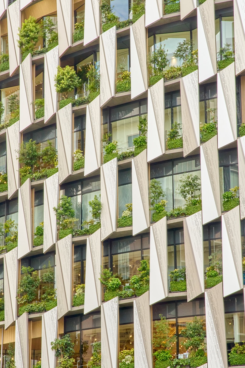 Modern building facade with integrated greenery and windows.